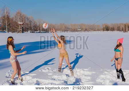 Novokuznetsk, Kemerovo region, Russia-23 Feb, 2017: White beaches of Siberia is an enterteiment activity where people playing beach games dressed in bikini in winter. Women playing volleyball on snow