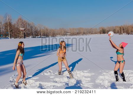 Novokuznetsk, Kemerovo region, Russia-23 Feb, 2017: White beaches of Siberia is an enterteiment activity where people playing beach games dressed in bikini in winter. Women playing volleyball on snow