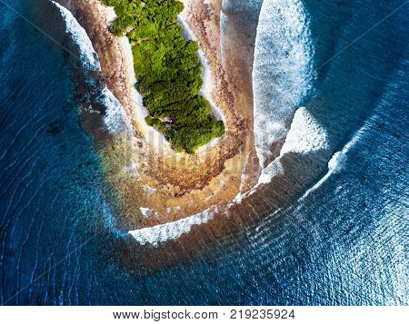 Aerial view of the tropical island of Kaafu atoll, Maldives. Island with famous surf spots named Sultans (at right) and Honkeys (at left side of the island)