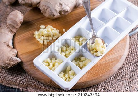 Pieces of ginger in a container for freezing ice cubes on a table