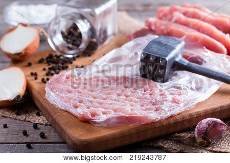 Raw chops on a cutting board on a wooden table