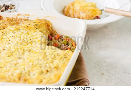 Shepherds Pie -  Irish Traditional Food. Served In A Ceramic Dish On A White Stone Background.