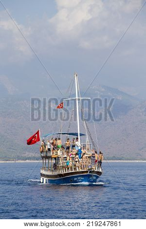 KEMER TURKEY - OCTOBER 23 2017 : Colorful boat with tourists returns from a cruise to the Kemer beach. The Kemer is very popular among tourists.