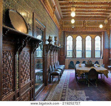 Cairo Egypt - December 2 2017: Manial Palace of Prince Mohammed Ali. Dining room at the Residence Building with ornate wall and ceiling Big ornate window built-in and wooden decorated cupboards