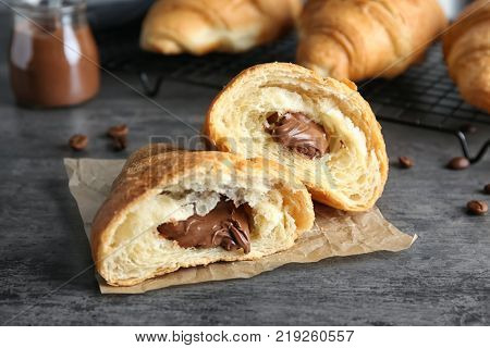 Yummy fresh croissant with chocolate on table