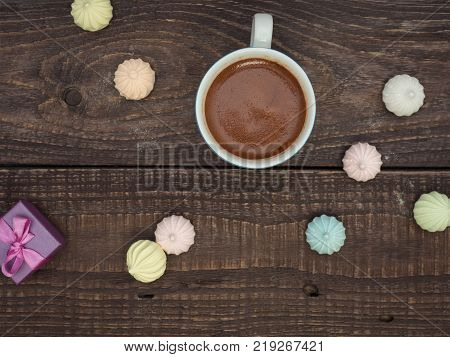 Freshly brewed cocoa and colorful bee on an old wooden table