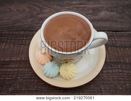 Freshly brewed cocoa and colorful bee on an old wooden table