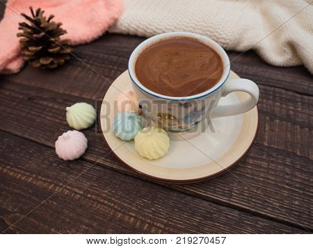 Freshly brewed cocoa and colorful bee on an old wooden table