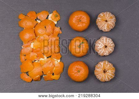 Fresh orange tangerine fruit mandarin pattern high vitamin C good for health top view on a black slate background close up