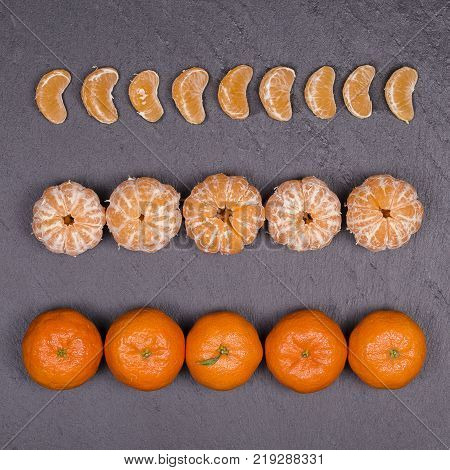 Fresh orange tangerine fruit mandarin pattern high vitamin C good for health top view on a black slate background close up