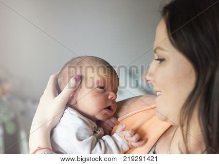 a young mother enjoys the first days of motherhood with her child holding it in her arms