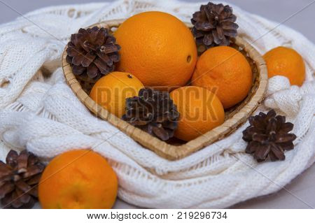 Mandarins and bumps in a wicker basket of Christmas decorations