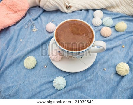 Freshly brewed cocoa with foam and colorful bise on the table