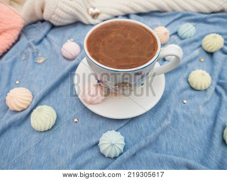 Freshly brewed cocoa with foam and colorful bise on the table