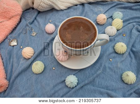 Freshly brewed cocoa with foam and colorful bise on the table