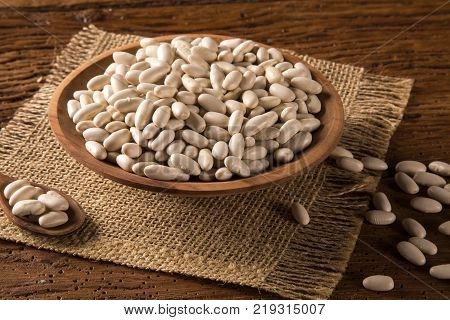 White beans ion a bowl on wood background