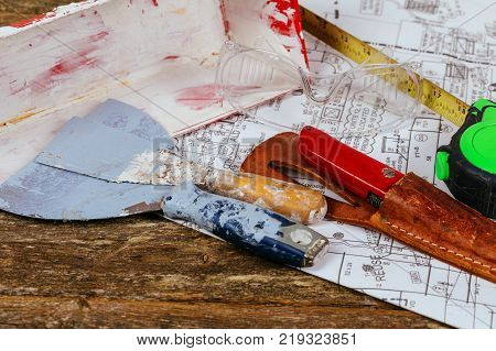 Set of assorted plaster tools and spatula on background old wood. Construction and renovation concept.