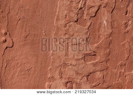 red sand stone texture pattern on surface of the wall. flaking red sandstone rock surface with topographic texture.