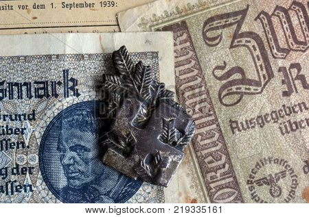 ILLUSTRATIVE EDITORIAL.Polish Army insignia (found with metal detector near Kiev).German vintage banknote WWII time.  .Kiev,Ukraine December 21 ,2017
