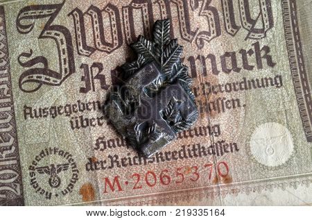 ILLUSTRATIVE EDITORIAL.Polish Army insignia (found with metal detector near Kiev).German vintage banknote WWII time.  .Kiev,Ukraine December 21 ,2017