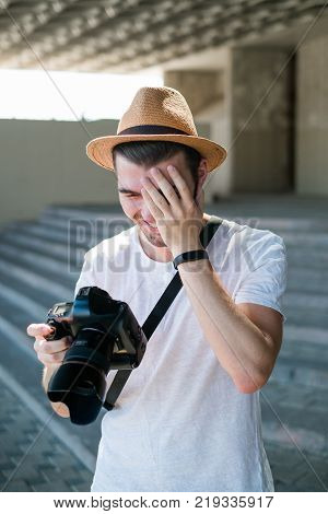 photography fails. professional photographer laughs at some bad shot. stupid accidental mistakes. working process concept