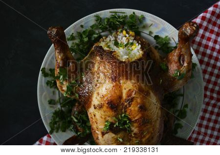 roast in the oven chicken with garnish on a platter with greens