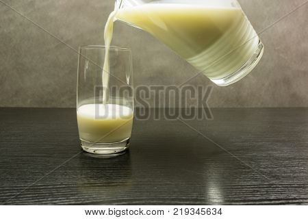 Pouring milk from a jug into a glass.