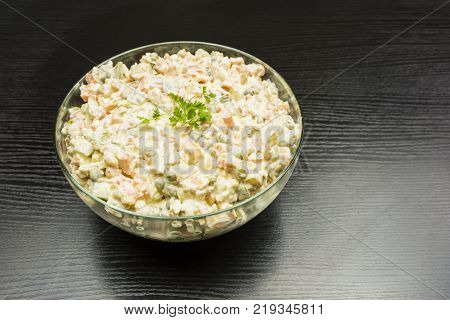 Dish for vegetarians. Bowl with vegetable salad prepared for the holiday on a wooden table.