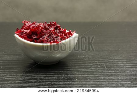 Bowl with grated boiled beets as an addition to dinner.