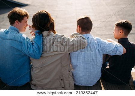 Men friendship. Back view of young teenagers hugging. Bff support unity teamwork concept