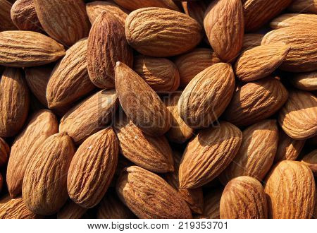 Closeup of Almond nuts heap abstract food product background