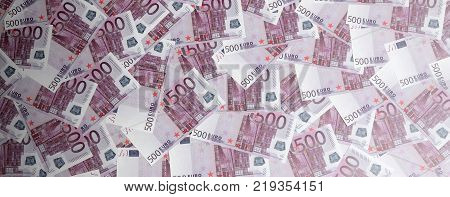 Money background consisting of purple five hundred Euro bills spread across the screen. Symbolic texture photo of wealth