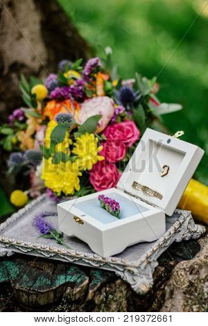 The wedding rings on nature with flowers.