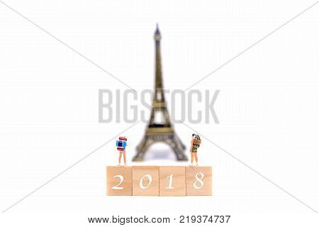 Happy New Year 2018. Miniature Group hiker and traveler backpack standing on wold map for travel Eiffel Tower in France and around the world. Holiday and Travel Concept