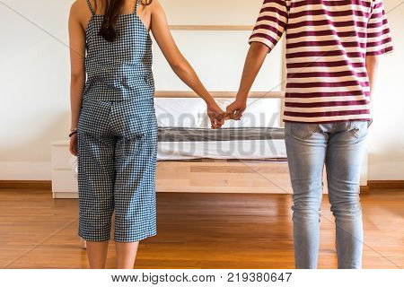 Men and women stand hand in front of the bed on Valentine's Day.