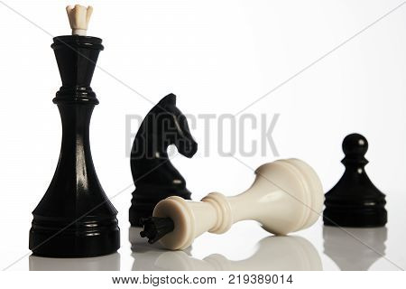 Chess game isolated on white background. Chess king is checkmated, chess game over. Black and white chess pieces business concept, leader success.