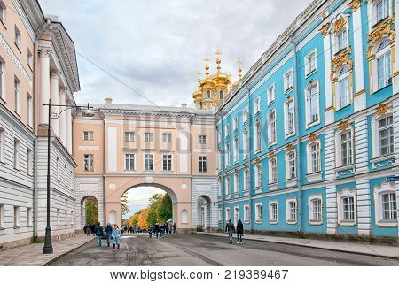 TSARSKOYE SELO, SAINT-PETERSBURG, RUSSIA - OCTOBER 7, 2017: People on the yard of the Imperial Lyceum (left). On the background is the arch between The Lyceum and The Catherine Palace Church Wing