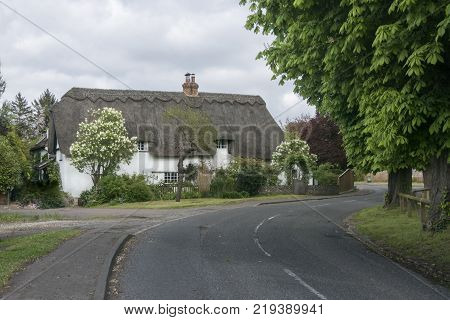 Street view of an old thatched cottage in the pretty village of Foxton Cambridgeshire England UK