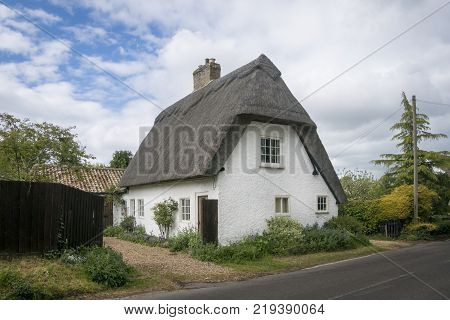 Street view of an old thatched cottage in the pretty village of Foxton Cambridgeshire England UK