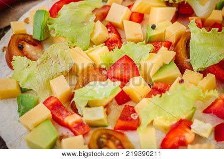 Tortilla with salad over it, surrounded by ingredients