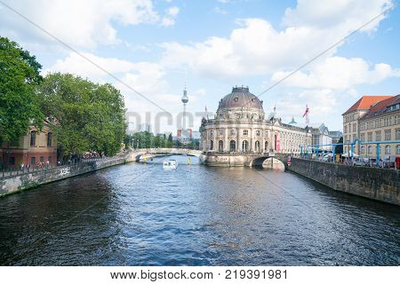 BERLIN GERMANY - AUGUST 28 2017; Baroque architectural exterior of Bode Museum from northern end of Museum Island surrounded by River Spree with Fernsehturm Tower behind.