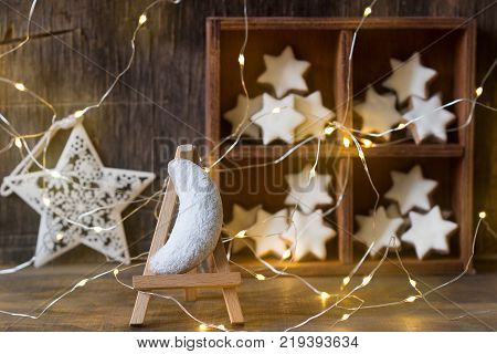 Vanilla crescents and cinnamon stars in the background with a garland, a wooden box and a star. Selective focus.