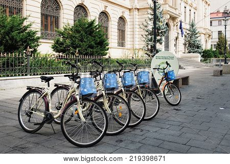 Bucharest, Romania - September 9, 2017: City bike stand with row of bicycles for rent at the historical center Lipscani Street in Bucharest, Romania.