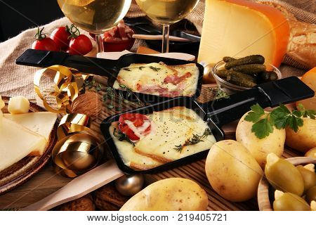 Delicious traditional Swiss melted raclette cheese on diced boiled or baked potato served in individual skillets.