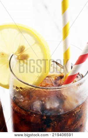 Softdrink With Ice Cubes, Lemon And Straw In Glass