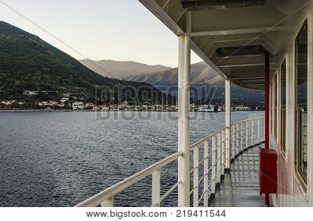 ferry railing and in the distance the port of Sami and its mountains in Kefalonia towards Pisaetos on the island of Ithaka