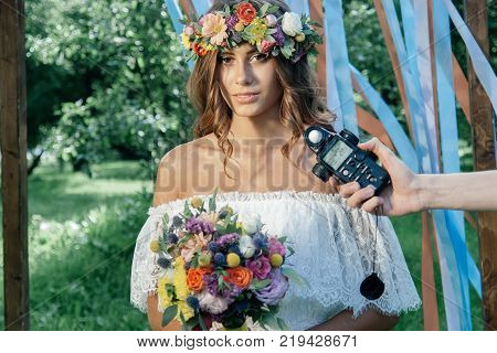 Photographer measuring light with light meter on beautiful girl.