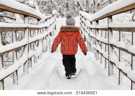 Little Cheerful Boy Runs In Winter On Bridge.