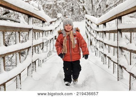 Little Cheerful Boy Runs In Winter On Bridge.