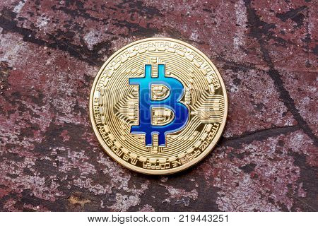Golden cryptocurrency blue bitcoin on red background. High resolution photo.